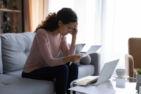 woman reading medical bills by laptop